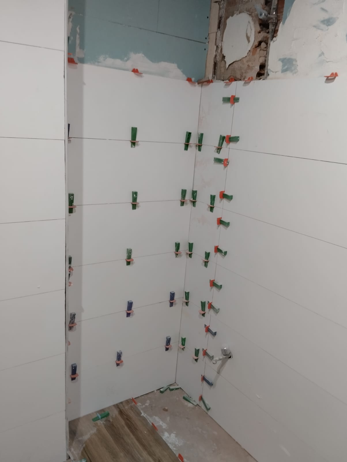 Baño reformado en un piso de Girona con plato de ducha enrasado, mampara de vidrio y alicatado nuevo