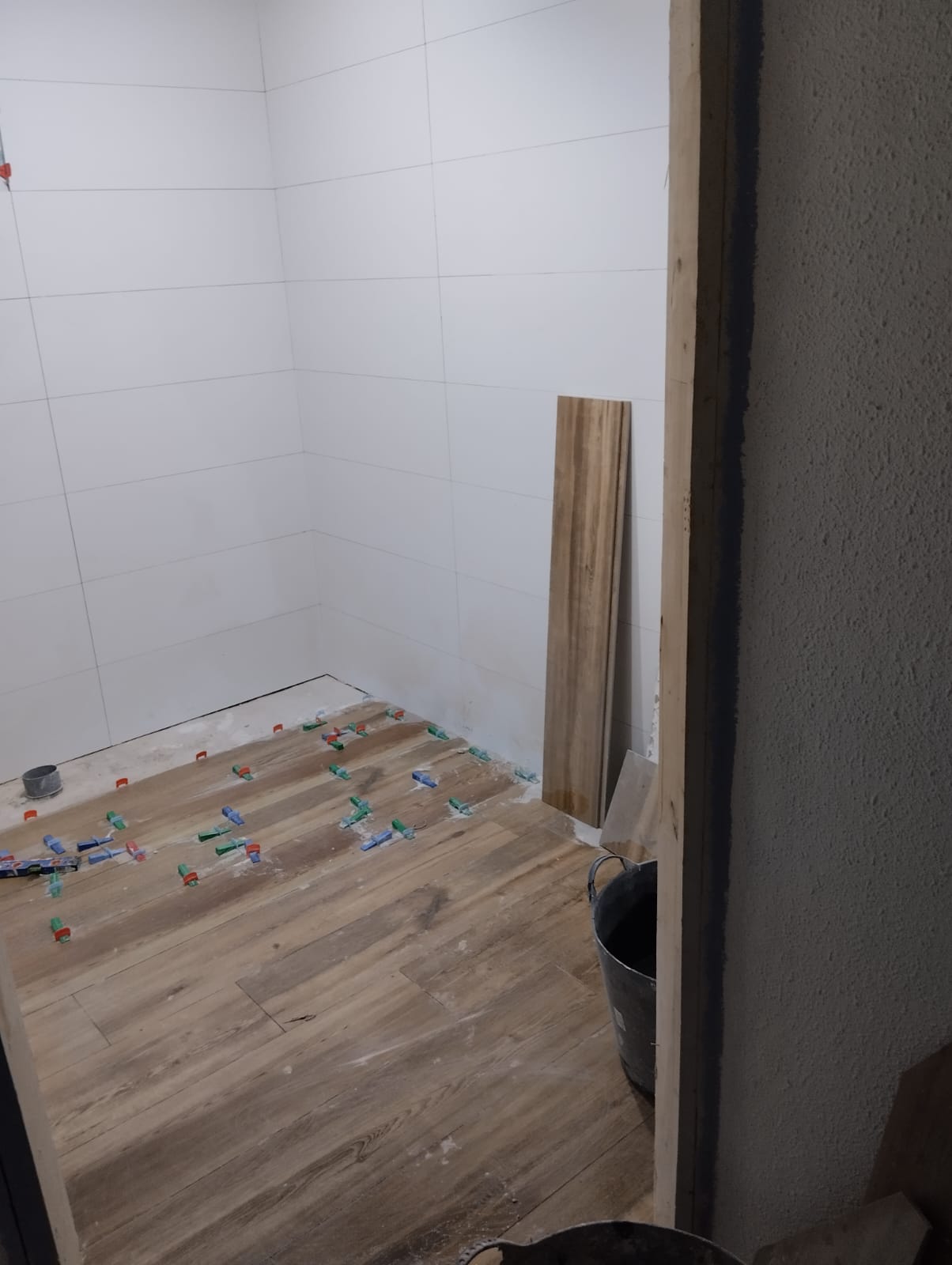 Baño pequeño de un piso antiguo de Girona reformado, con lavabo suspendido, espejo iluminado y porcelánico de gran formato
