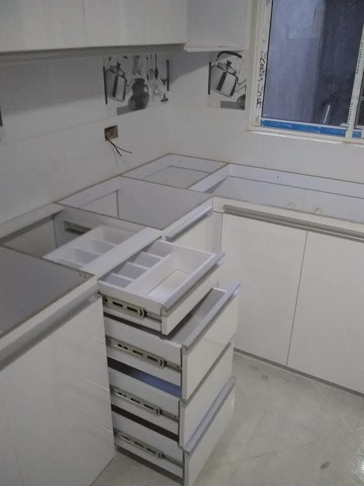 Detalle de alicatado y encimera nuevos en una cocina reformada, con impermeabilización en la zona húmeda