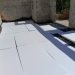 Paneles de aislante sobre la solera entre muros de bloque en obra nueva
